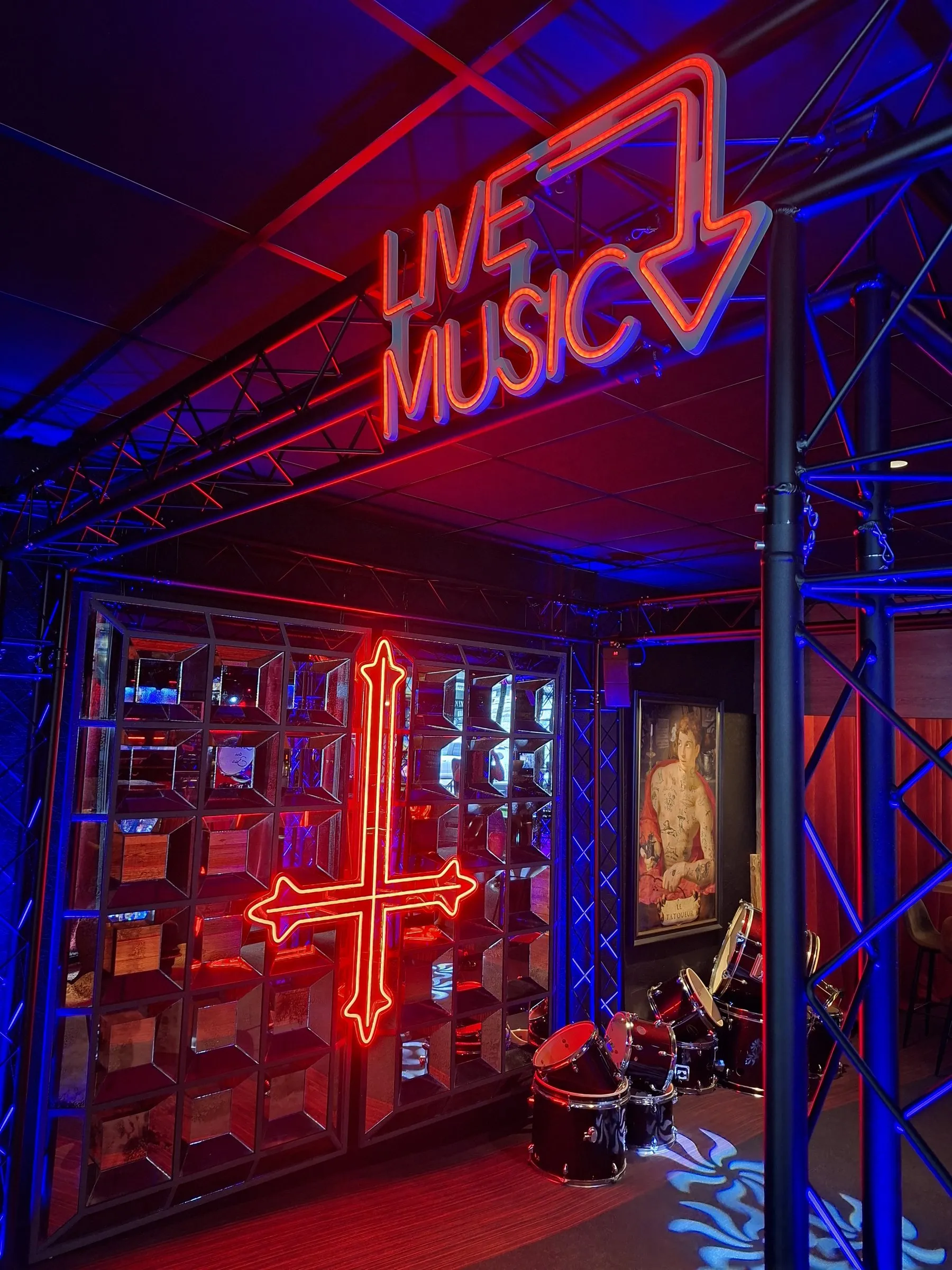 Le néon « Live Music » et la croix rouge au-dessus de la scène